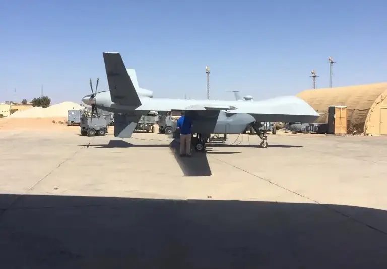 A military aircraft parked on the tarmac at an airport.